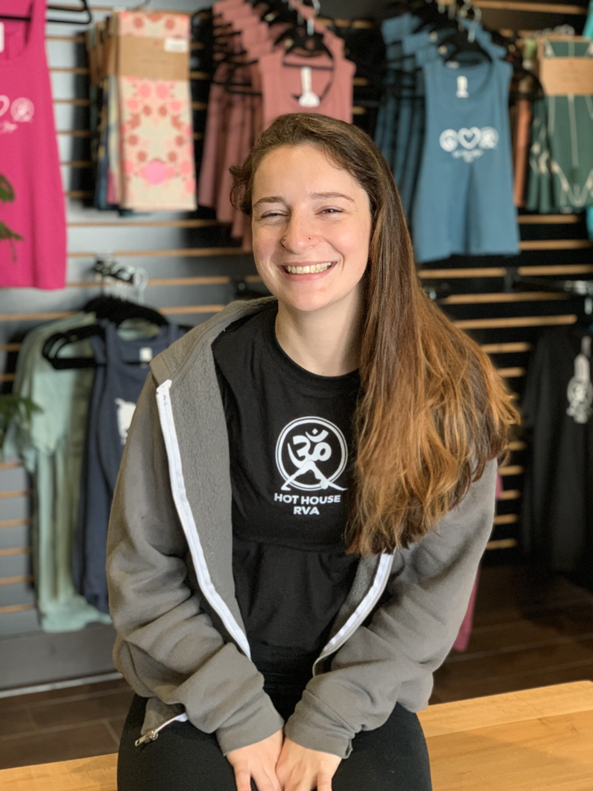 A girl sitting in front of a store window.