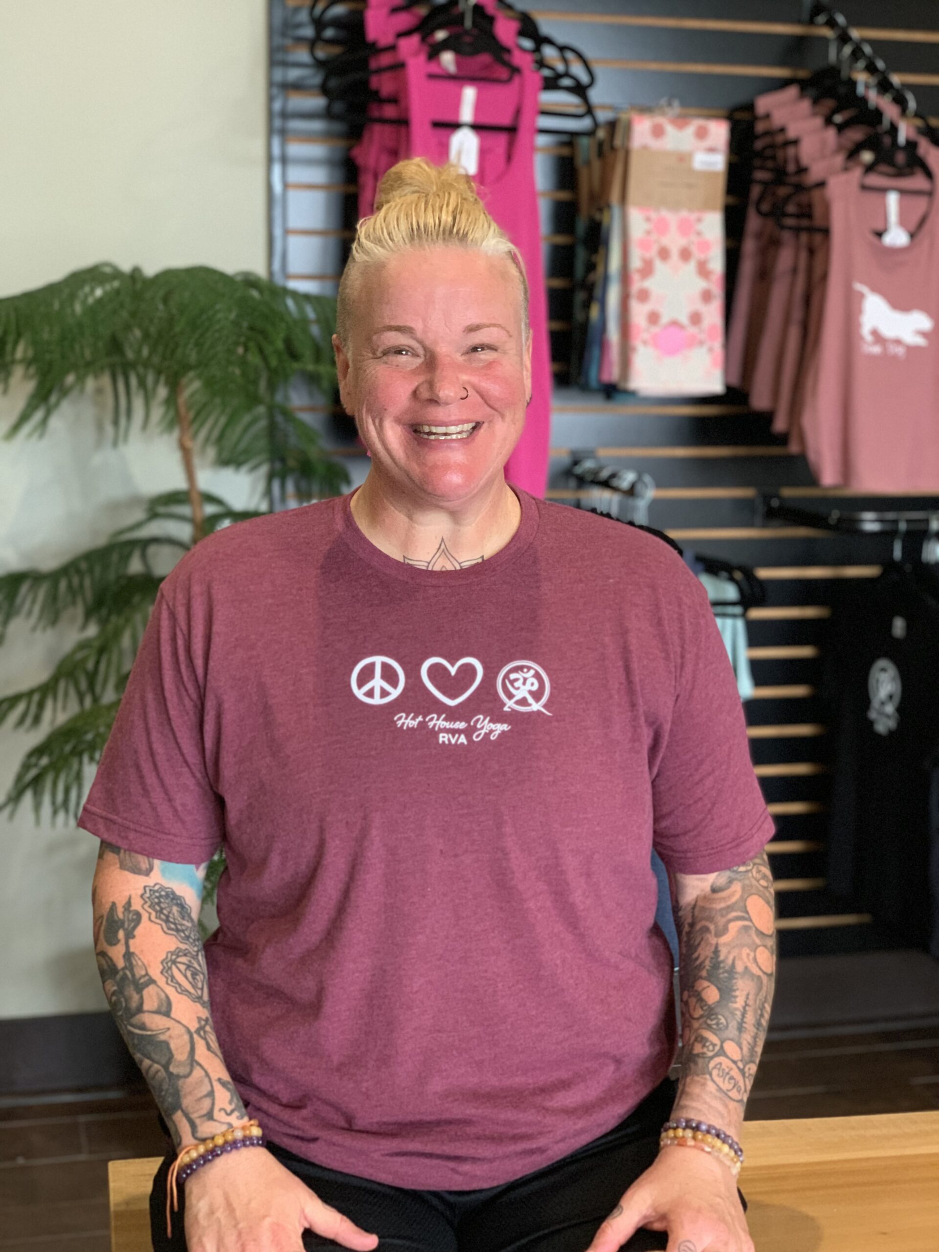 A woman with tattoos and a peace sign shirt.